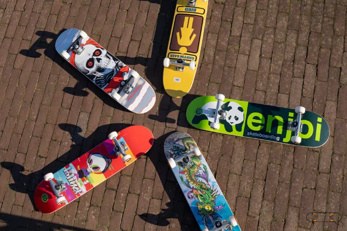 5 kids skateboards laying on the ground