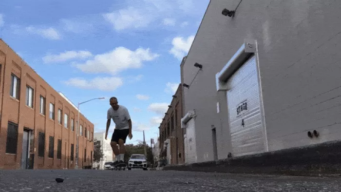 A backside tailslide in action, showcasing the tucked-up body position and sideways drift