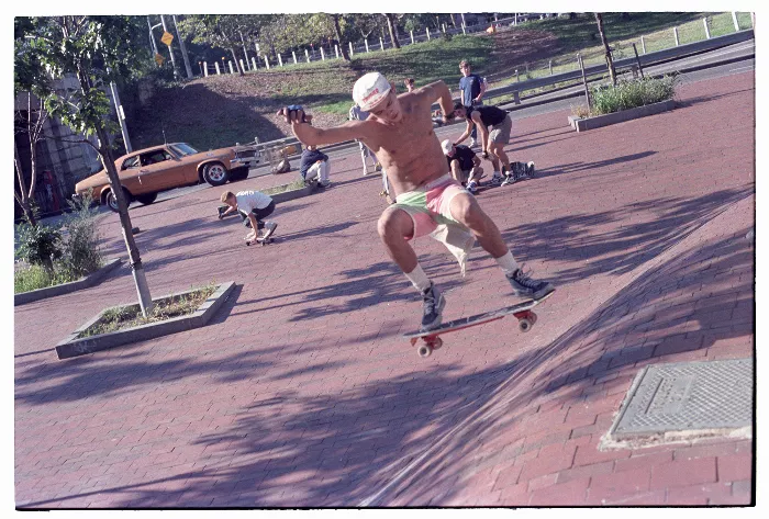 A black and white photo shows a skateboarder performing a trick on a ramp