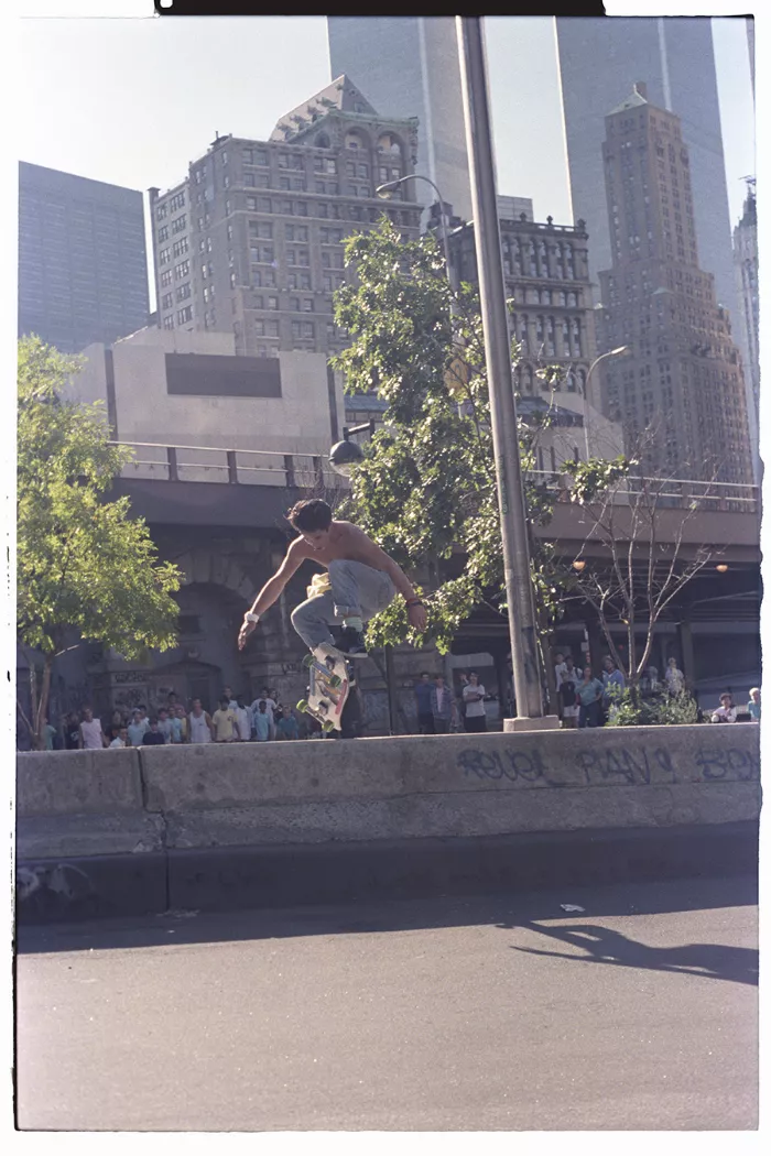 A black and white photo shows a skateboarder performing an ollie over a gap