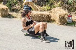 A close-up of a longboard and a helmet next to it