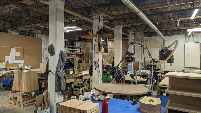 A close-up of Rob Pluhowski working on a piece of furniture, highlighting his attention to detail