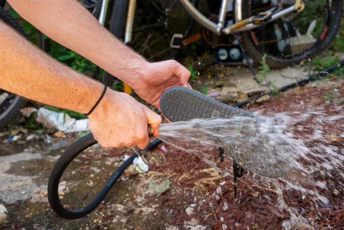 A close-up of the Adidas Jason Dill Samba skate shoe being cleaned with high-pressure water, showing the poop being washed away.