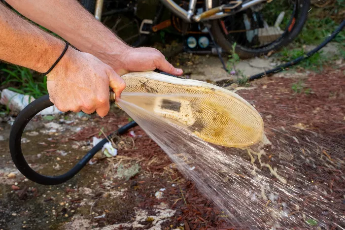 A close-up of the Converse x Jenkem Jack Purcell Pro skate shoe being cleaned, requiring a thin tool to remove the dog poop from the grooves.