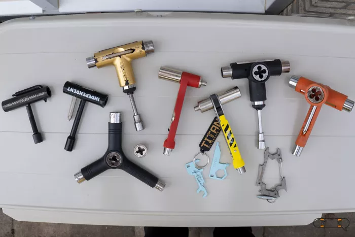 A close up of various skate tools, including multi-tools and a specialized bearing tool.