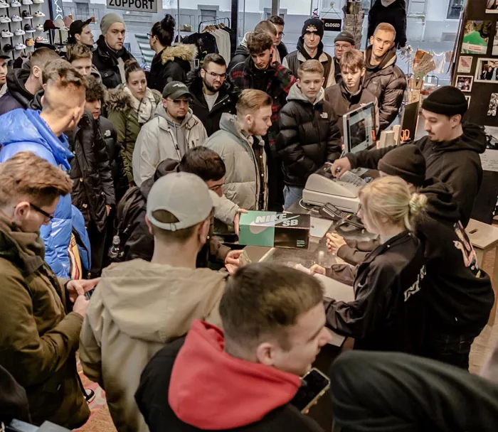 A crowd of people gathered outside a skate shop, presumably for a limited shoe release.