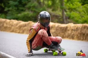 A downhill skateboarder wearing a full-face helmet