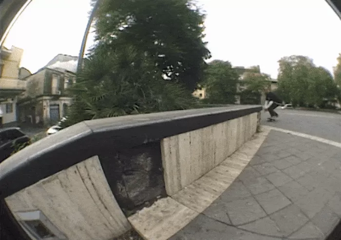 A GIF showing a longboarder making a smooth turn on a cobbled street