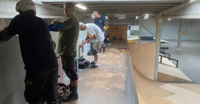 A group of older skateboarders enjoying themselves at a skatepark, highlighting that skateboarding is a sport for all ages.