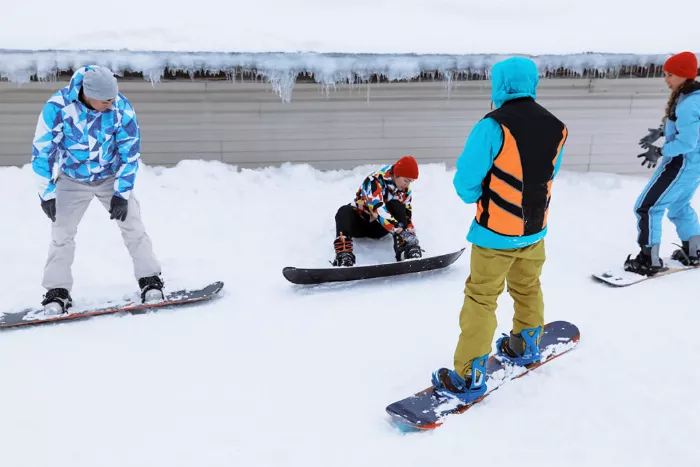 A group of snowboarders receiving instructions from their instructors