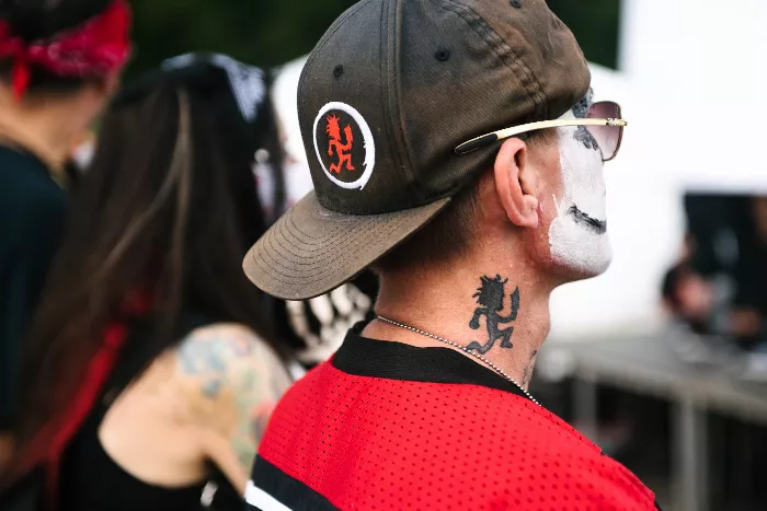 A large crowd of people with painted faces gathered in front of a memorial.