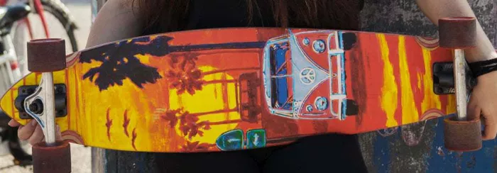 A longboard positioned on a street, showing its length and deck design.