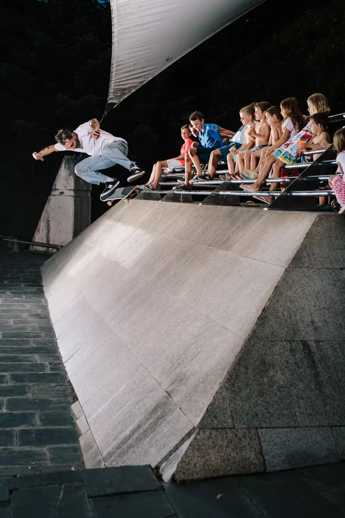 A longboarder performs a trick on a quiet street in a small town during a longboard trip.