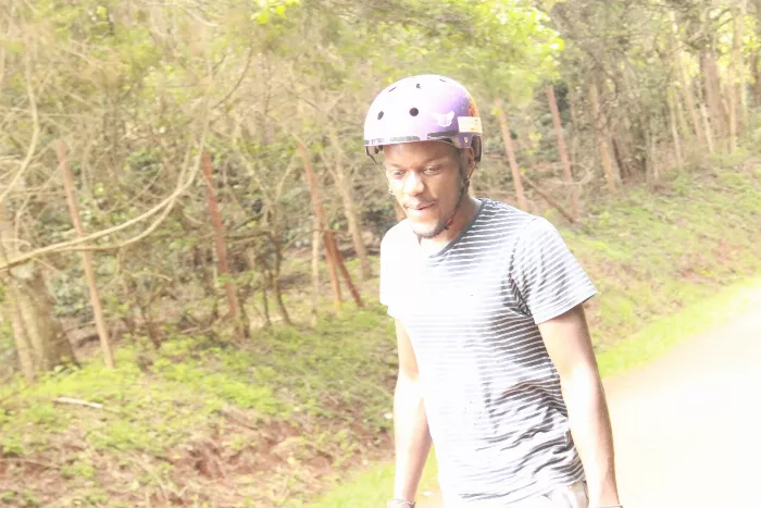 A longboarder standing with their board, looking slightly disheveled