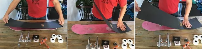 A person applying new grip tape to a longboard deck