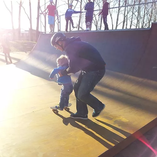 A person riding a Penny board, showing its compact size and ease of carrying