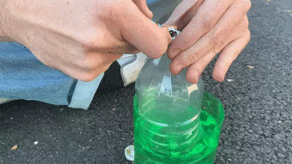 A person using a homemade gravity bong.