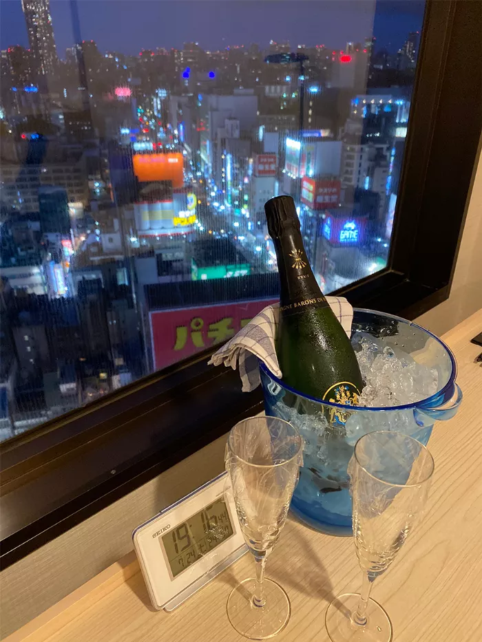 A photo of a hotel room with a bottle of champagne and two glasses.