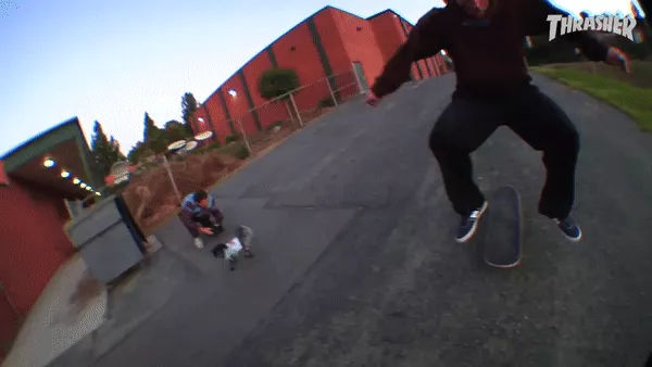 A skateboarder attempting a trick, the board is mid-snap