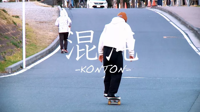 A skateboarder in motion, captured mid-trick with a clean urban backdrop.