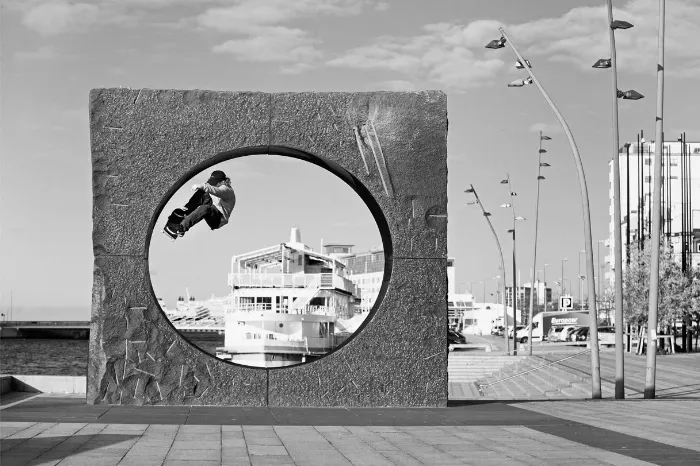 A skateboarder performing a trick on a public art sculpture