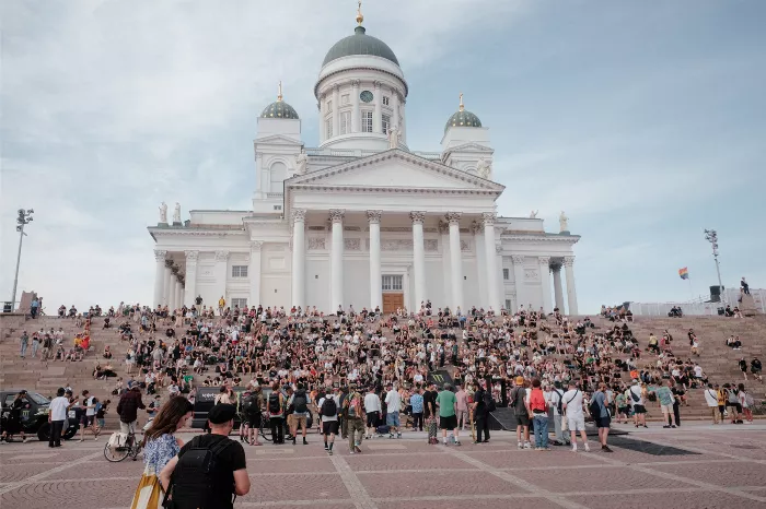 A skateboarder performs a trick at the Helsinki HELride event, with spectators watching in the background