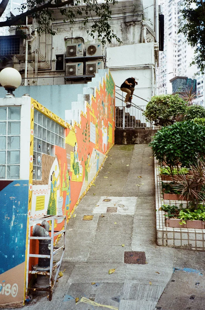 A skateboarder performs a trick on a unique structure on the street, highlighting the contrast between old and new architecture