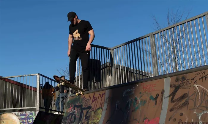 A skateboarder preparing to drop into a quarter pipe