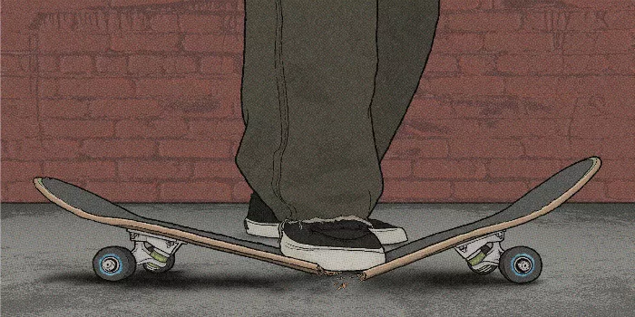 A skateboarder stands on a broken board, holding the two pieces, with a concrete background