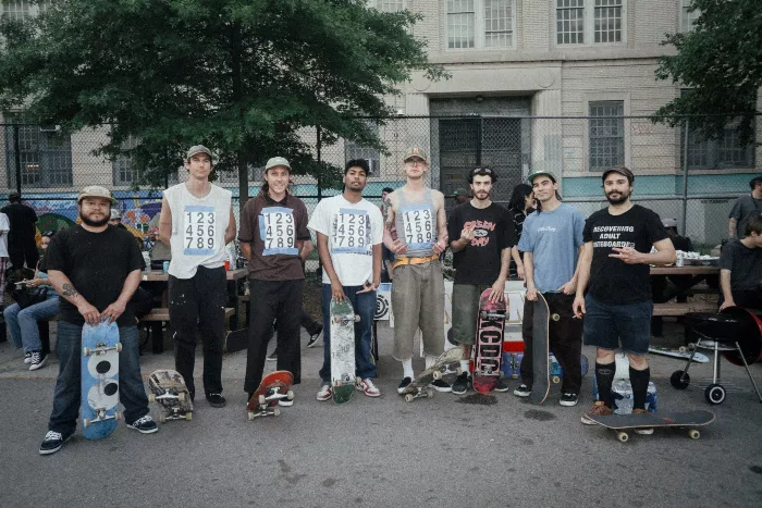 A skater mid-tre flip with onlookers in the background