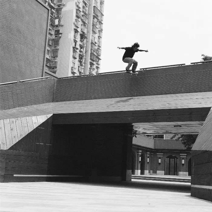 A skater ollies over a metal beam