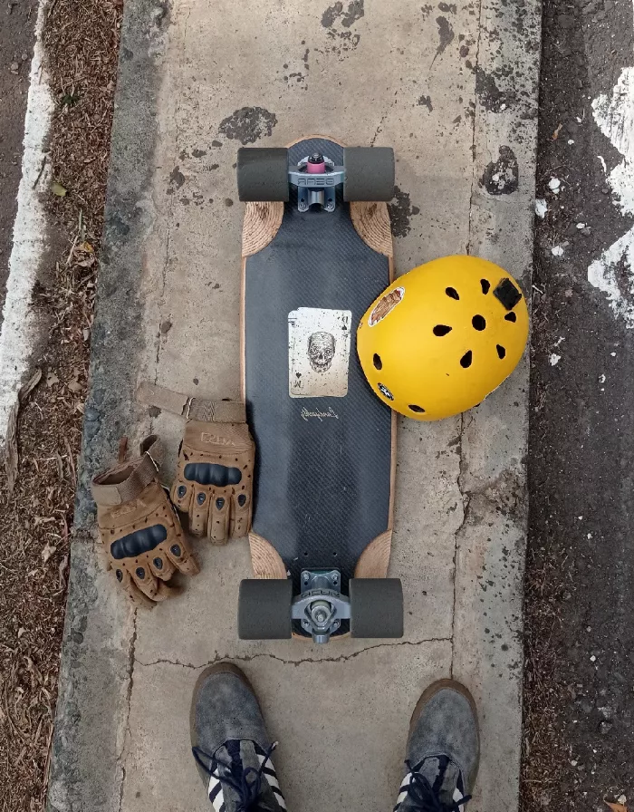 A skater wearing a full-face helmet and slide gloves, showcasing the essential safety gear for downhill skateboarding