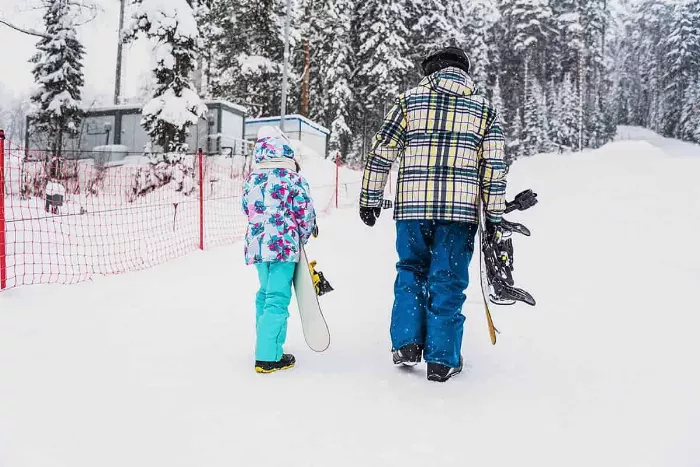 A snowboard instructor giving a lesson to a beginner