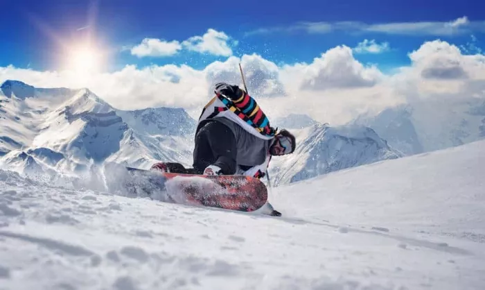 A snowboarder carving through fresh powder snow