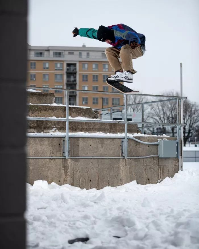 A snowskater performing a heelflip