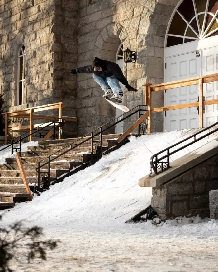 A snowskater performing a heelflip