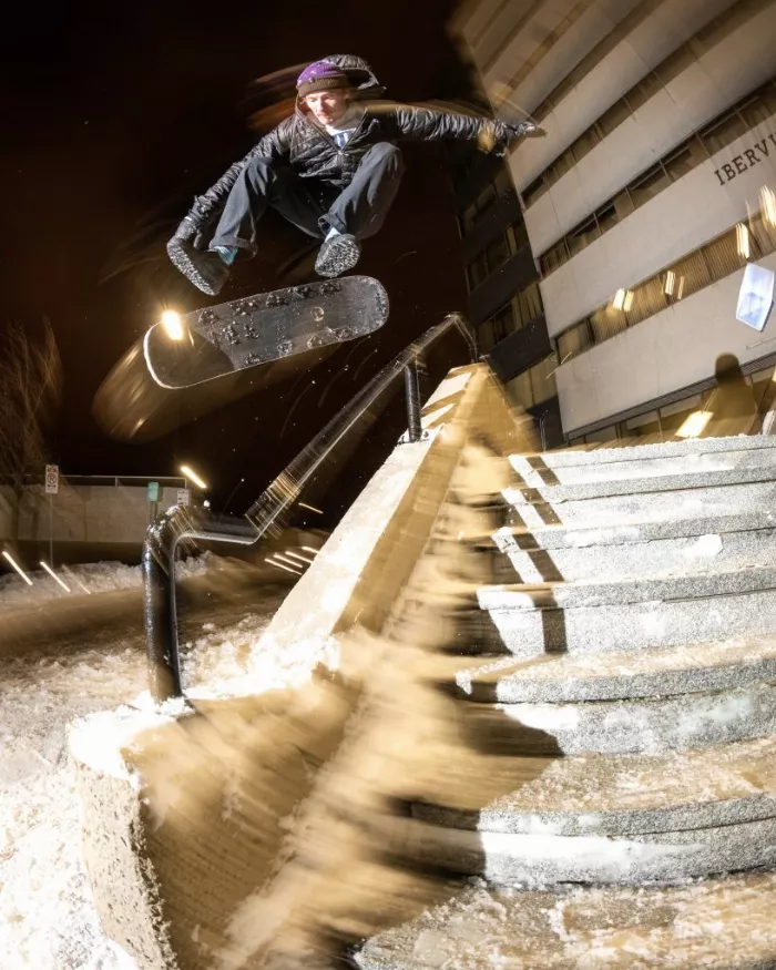 A snowskater performing a kickflip