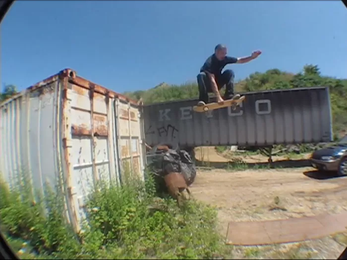 A still from the BLE video showing three people standing outside, one is holding a skateboard.