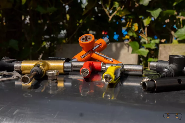 A variety of different skateboard and longboard tools displayed on a wooden surface