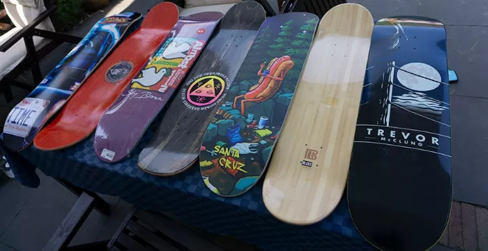 A variety of skateboard decks displayed on a table, highlighting different colors and graphics