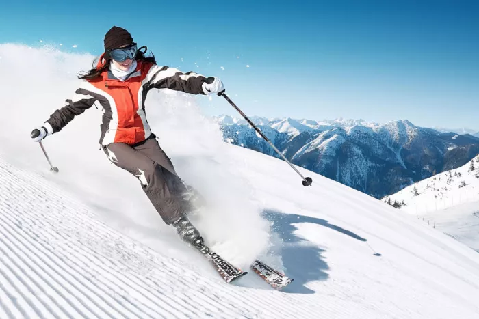 A woman skiing down a mountain on a sunny day