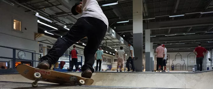 Adult man longboarding at a skatepark, showcasing a smooth ride