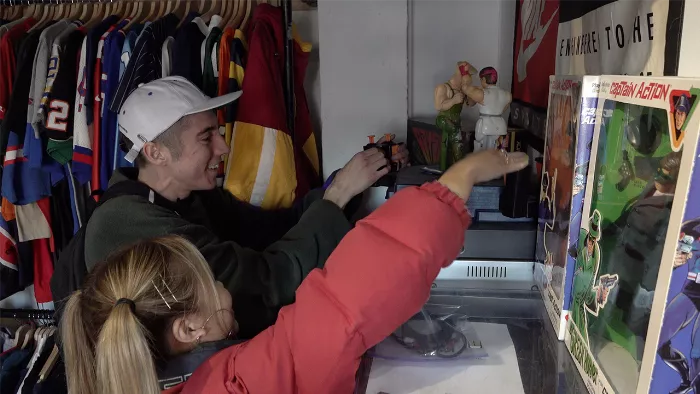 Aleka Lang performs a skateboard trick while Jess Wong watches, showcasing the blend of skating and thrifting.