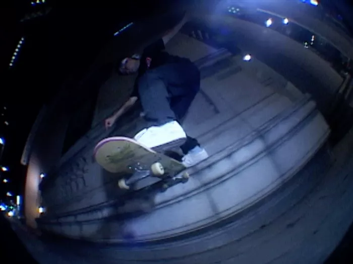 Another still image from the &quot;Pale&quot; skateboarding video showcasing a different trick in another unique urban spot, the lighting is moody with a focus on the skateboarder's motion