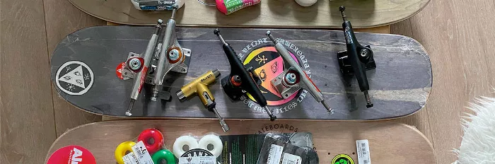 Assorted longboard parts including decks, trucks, and wheels on display