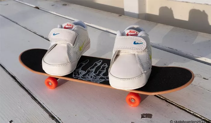 baby sneakers on a hand skateboard