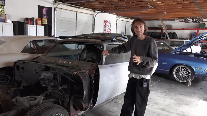 Bryan Herman standing next to a classic car, showcasing his diverse interests beyond skateboarding.