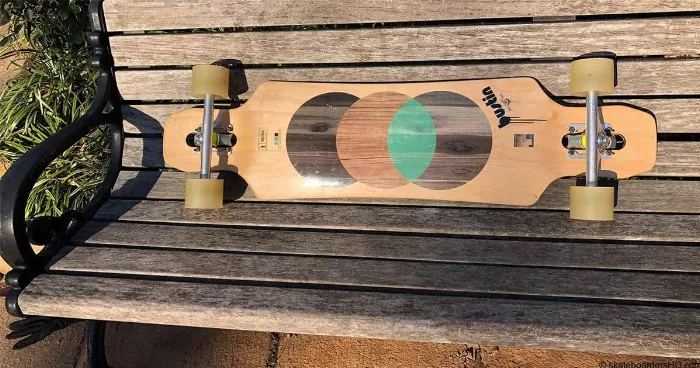 Bustin Maestro longboard on a bench