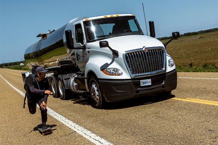 Chad Caruso skateboarding on a highway with cars passing