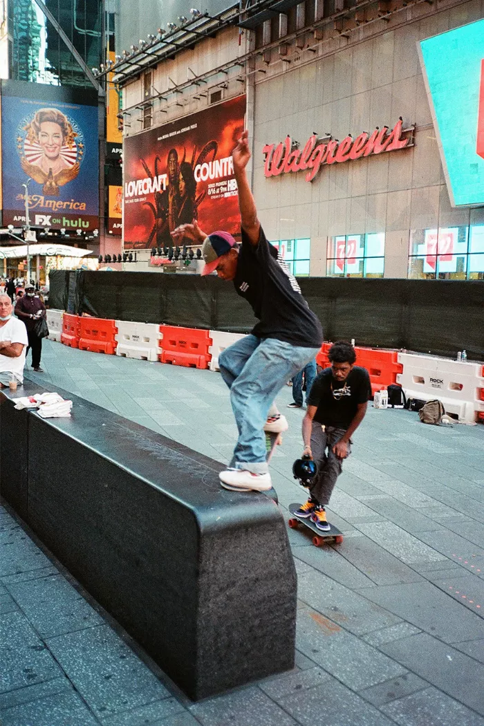 Christian Henry doing a trick on a bench in Times Square.